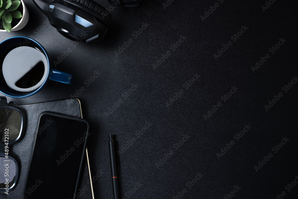 Poster top view working desk with keyboard headphone and mobile phone on black table background