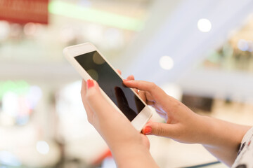 Hands using mobile smart phone and take a photo in display view of a clothing store, shopping online concept