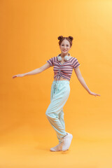 Fototapeta na wymiar Young pretty girl jumping isolated on yellow background.