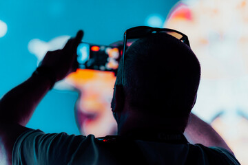 silhouette of a man taking photos using a phone