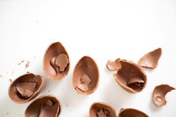 Happy Easter. Open broken destroyed crumbled chocolate eggs on a white background. Holiday.