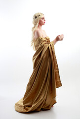  Full length portrait of pretty female model wearing  grecian goddess  toga gown, posing with elegant gestural movements on a studio background. - obrazy, fototapety, plakaty