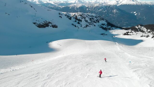Aerial drone footage of skiers and snowboarders on Whistler mountain, BC, ski hill, winter sport, Canada. 4K 24FPS.