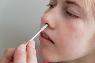 Teenage girl doing rapid antigen test nasal swab. Rapid diagnostic test kit