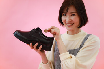 革靴に10円玉を入れる女性
