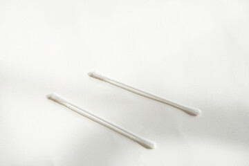 Two cotton bud on white background in shadow and light in the window light.