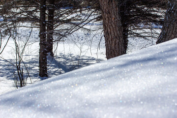 Close-up abstract texture background of heavy snow on the end of a home rooftop, with faint tree...