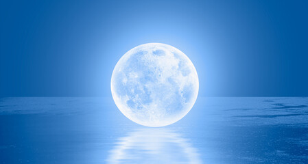Blue full moon standing over the sea 