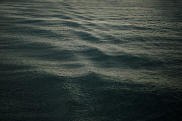 Calm ocean waves background. Rippled water on a sea at sunset.