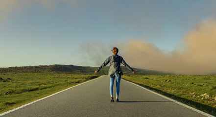 Woman opening arms on a lost road in the tip of Galicia