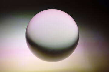Colors reflected in a glass ball on a multicolored background