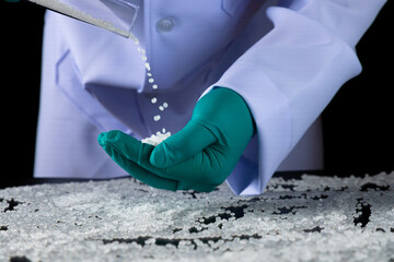 Employees wearing green gloves work with plastic beads.close-up shot of polymer pallet. Products...