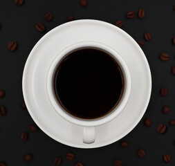Obraz na płótnie Canvas top view of white ceramic cup hot coffee roasted coffee beans on a dark background 