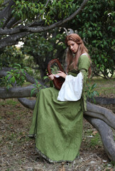 Full length portrait of blondewoman wearing a  beautiful  green medieval fantasy gown. Posing with...