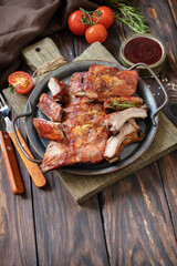 BBQ grilled veal calf brisket meat on short spare rib on plate over rustic wooden table. Copy space.