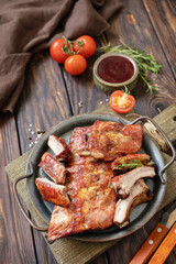 BBQ grilled veal calf brisket meat on short spare rib on plate over rustic wooden table.