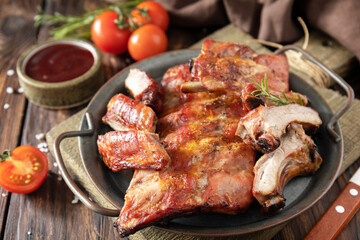 BBQ grilled veal calf brisket meat on short spare rib on plate over rustic wooden table.