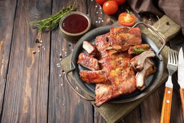 BBQ grilled veal calf brisket meat on short spare rib on plate over rustic wooden table. Copy space.