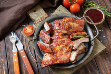 BBQ grilled veal calf brisket meat on short spare rib on plate over rustic wooden table.