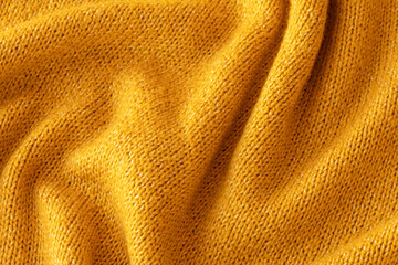 Soft knitted yellow sweater texture closeup. Light orange abstract background. Trendy soft...