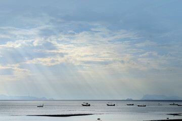Fishing boats in the sea with sun rays sky after the rain.