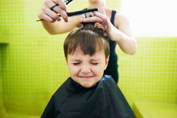 His first haircut. Cropped shot of a young boy getting his first haircut.