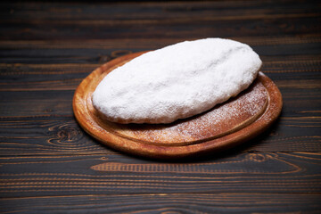 Traditional Christmas stollen cake with marzipan and dried fruit isolated on wooden background