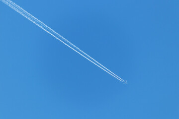Condensation trail of a flying jet plane in the blue sky