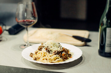 Pasta bolognese with a glass of pinotage red wine. Wine from the Pinotage grape variety. Italian cuisine at home. Dishes of Italian cuisine with your own hands.