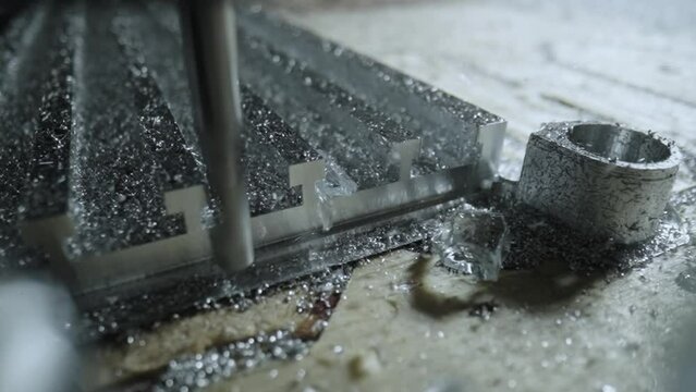 Milling cnc machining. Cutting tool processing metal detail on milling machine in workshop. Metalworking milling machine. Produces metal parts in a factory. Close up of the detail. Slow motion.