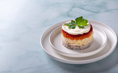 Traditional russian salad with herring and vegetables on a green background