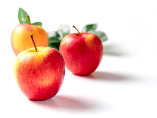 Bright apples with leaves on a white background