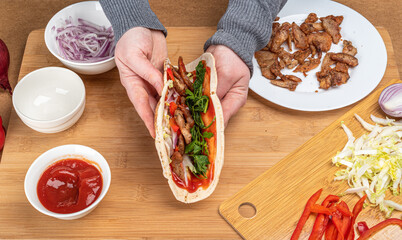 Freshly cooked Lebanese pita kebab in the hands of a woman.