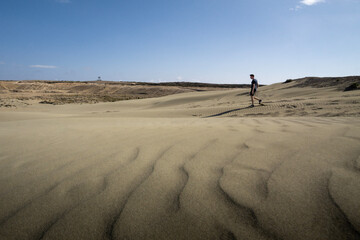 Fototapeta na wymiar tourist walks on sand dunes at Akrotiri island