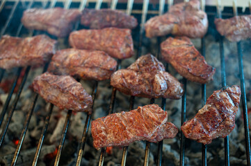 Juicy steaks from marble veal lie on the grill grill