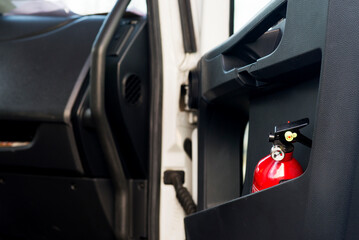 Red fire extinguisher in a black truck door.