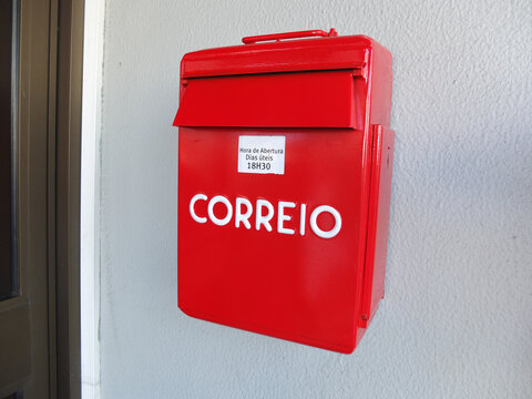 Red steel mailbox on the wall. Lettering in portugal : "Correio." Selective focus.
