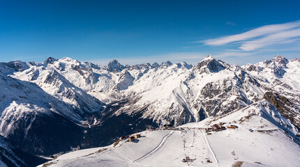 Panorama of winter snowy mountains in Caucasus region in Russia with ski lift and ski track