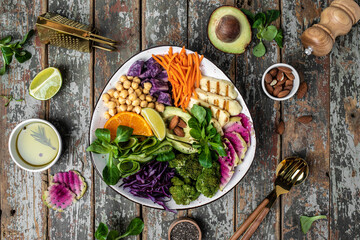 Healthy vegetarian buddha bowl salad with halloumi cheese, avocado, cucumber, chickpeas, watermelon radish, potato purple sweet. ketogenic paleo diet. Clean eating, vegan food concept. top view