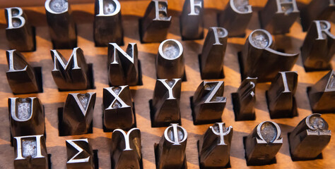 Old metal alphabet letters, letterpress machine - obrazy, fototapety, plakaty