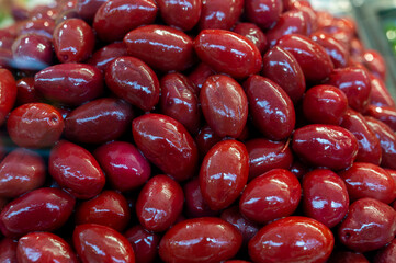 Red olives close up on market, food background