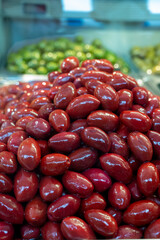 Red olives close up on market, food background