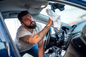 Young man cleaning his car