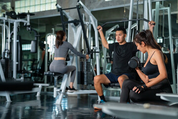 Fototapeta na wymiar Healthy Asian athletic man and woman in sportswear workout exercise weight lifting at fitness gym. Male and female do body building weight training at sport club. Health care motivation concept