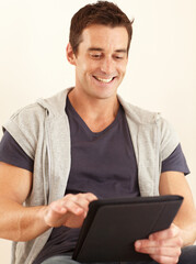 Loving my new digital tablet. A handsome young man using his digital tablet.