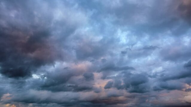 4k time lapse. Rolling dark clouds in the blue sky. Black clouds landscapes at sunset.
