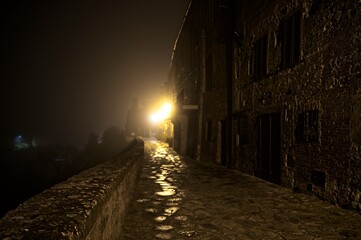Fototapeta na wymiar Foggy Night in a Medieval Village in Umbria Italy in Winter