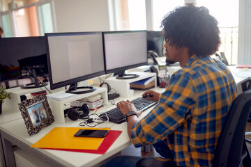 Obraz na płótnie Canvas Young afroamerican male programmer working