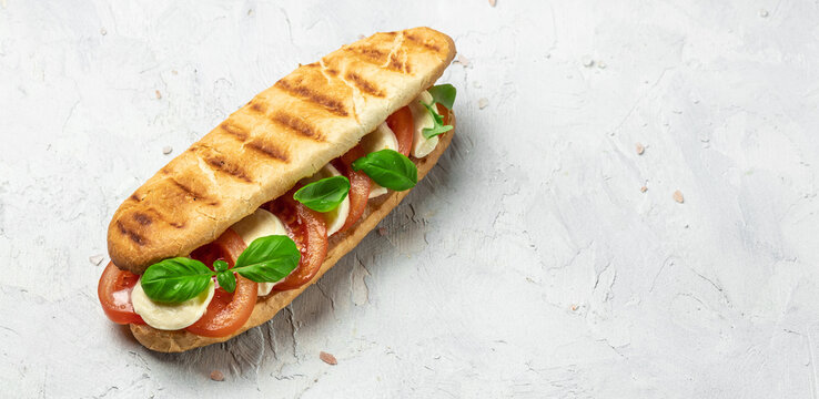 Pressed and toasted panini caprese with tomato, mozzarella and basil, Caprese Panini Sandwich. Delicious breakfast or snack, Clean eating, dieting, vegan food concept. top view