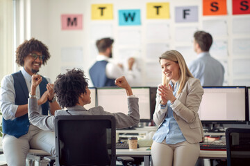 A group of cheerful employees is having a friendly talk in the office. Employees, job, office